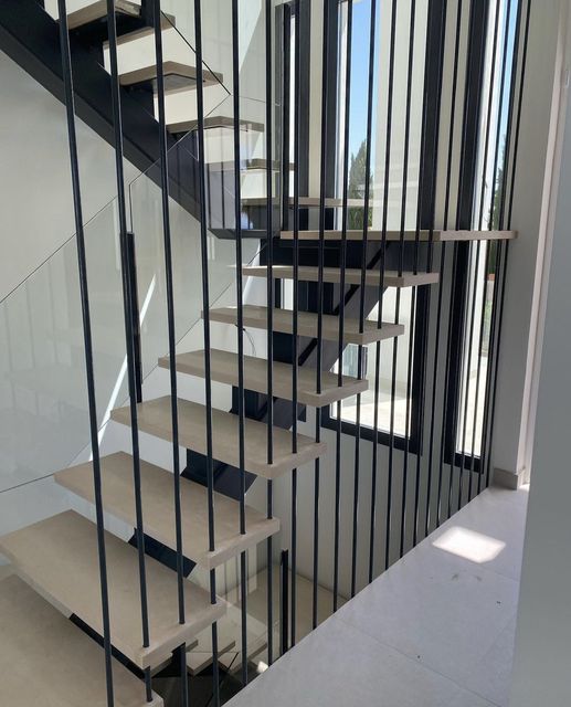 Barandilla metálica negra en escalera interior moderna
