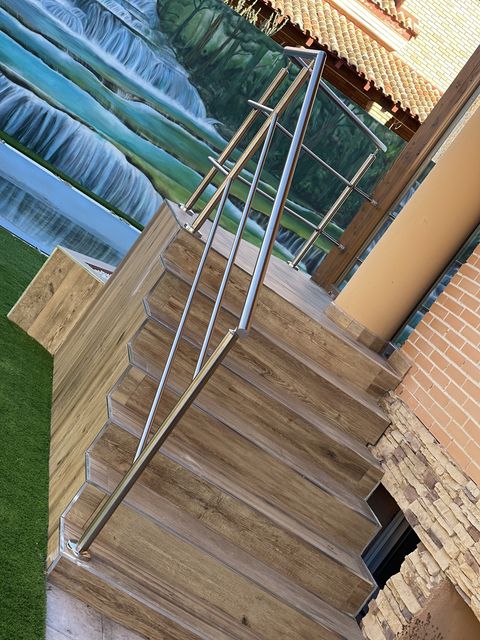 Pasamanos de acero inoxidable en escalera de madera exterior