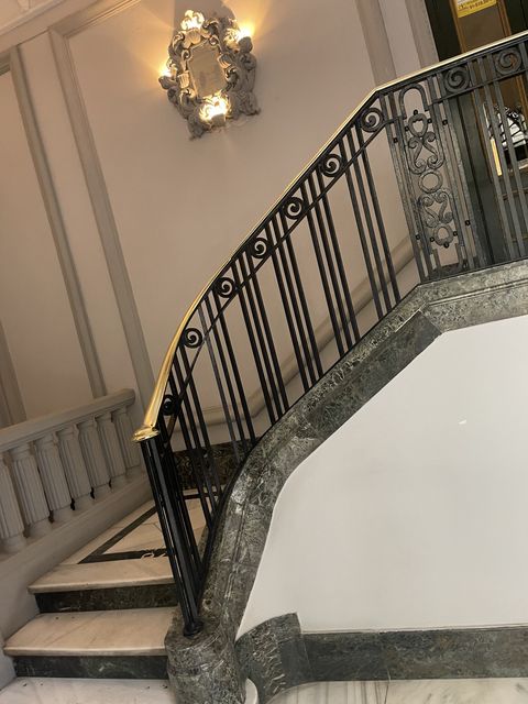 Barandilla de forja curva en escalera de mármol