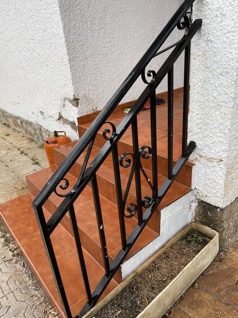 Barandilla de forja con motivos decorativos en escalera exterior