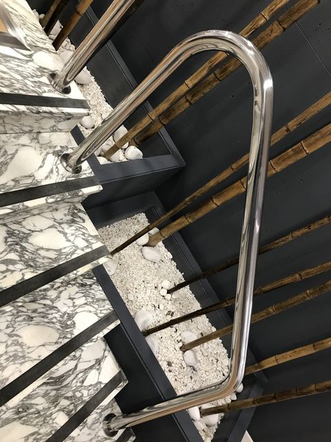 Detalle de pasamanos de acero inoxidable en escalera de mármol