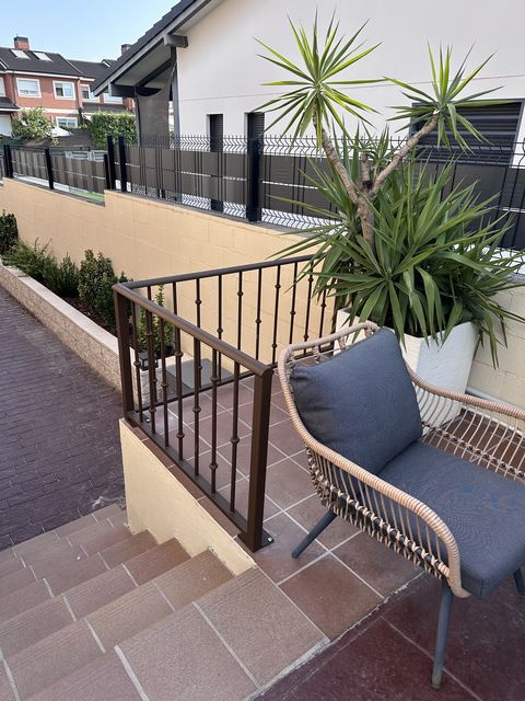 Barandilla metálica marrón en escalones de terraza