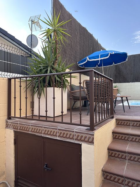 Barandilla metálica marrón en terraza sobre una puerta metálica