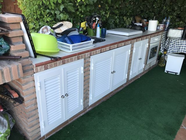 Puertas tipo persiana metálica en mueble de cocina exterior