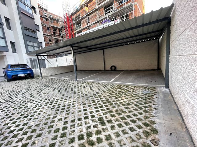 Estructura de pérgola metálica cubriendo plazas de aparcamiento