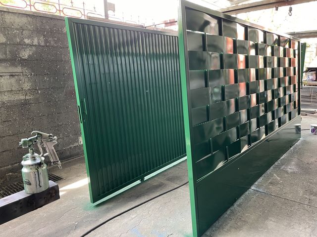 Puerta metálica con diseño decorativo entrelazado en verde