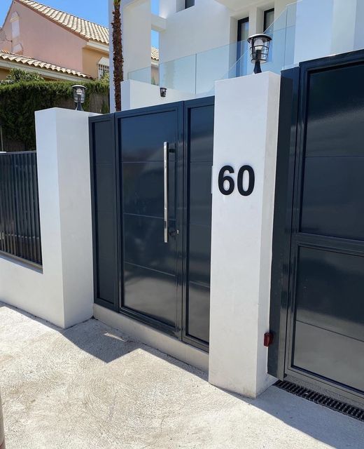Puerta metálica moderna en acceso a vivienda