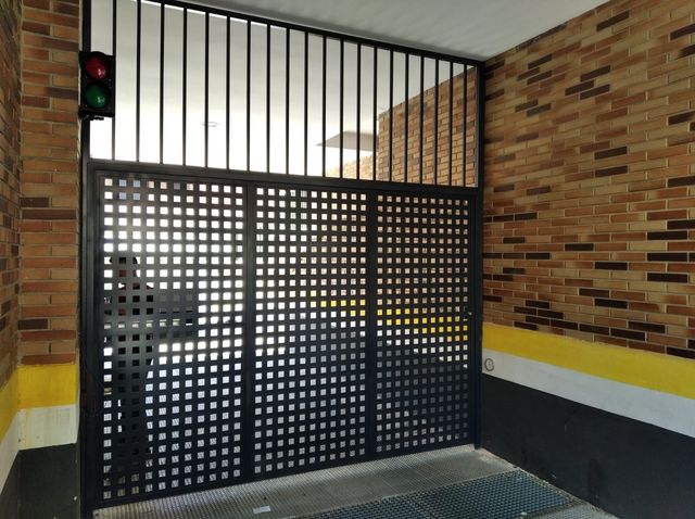 Puerta metálica con panel perforado decorativo