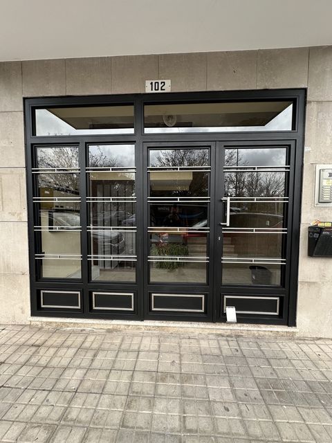 Puerta de portal con paneles acristalados en acceso comercial