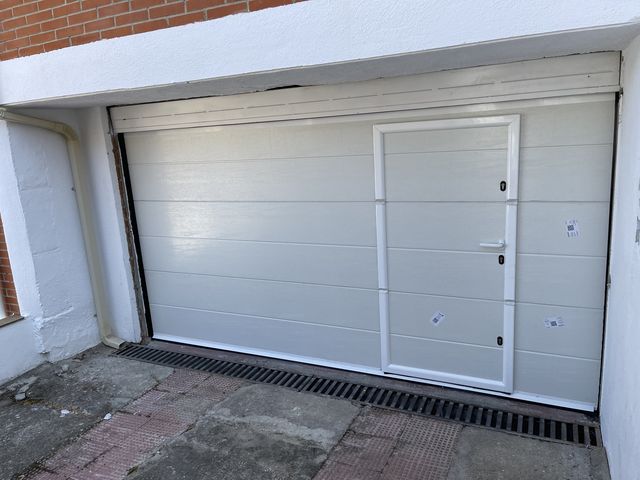 Puerta de garaje metálica seccional con acceso peatonal integrado