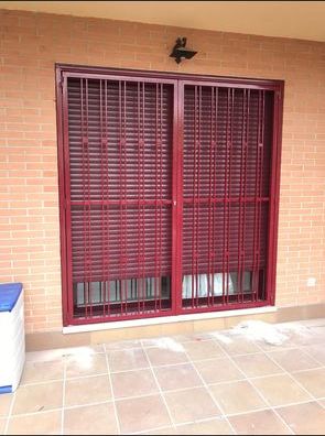Reja metálica de ventana junto a persiana