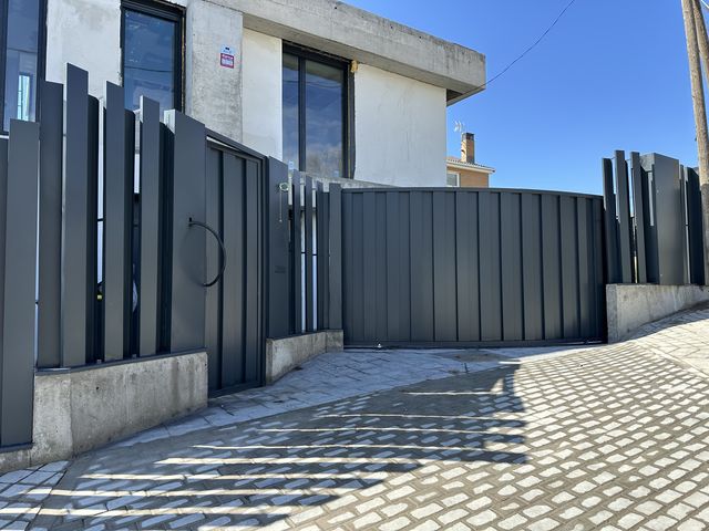 Valla metálica de paneles con lamas verticales y cancela corredera