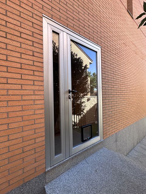 Puerta acristalada de dos hojas con marco de aluminio